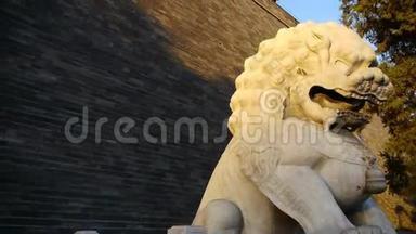 石狮矗立在中国古代建筑的古城墙上。